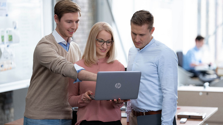 Agile Lernformate – drei Personen schauen gemeinsam in einen Laptop (Foto)